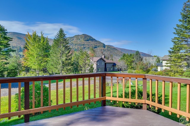 wooden deck featuring a mountain view and a yard