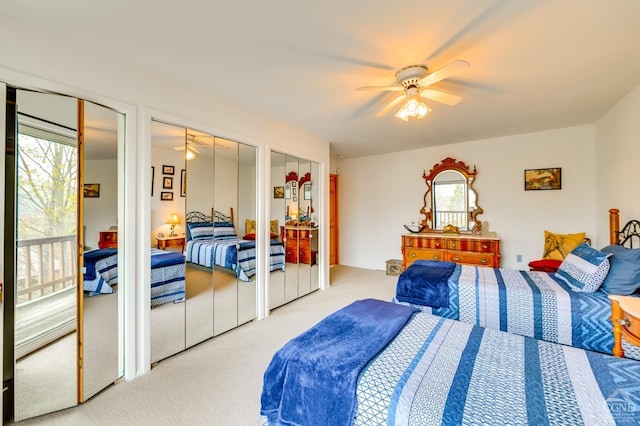 bedroom featuring carpet flooring, ceiling fan, multiple windows, and two closets