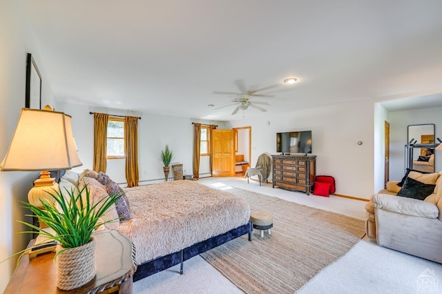 bedroom with ceiling fan, light colored carpet, and a baseboard heating unit