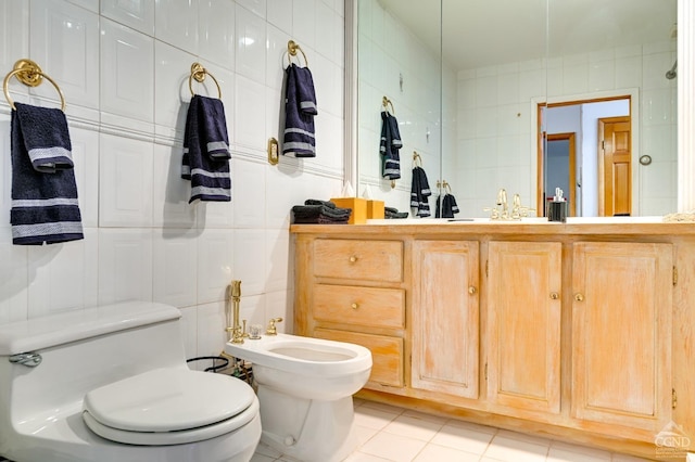 bathroom featuring tile patterned flooring, toilet, tile walls, and a bidet