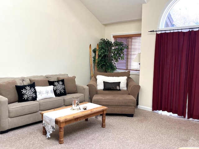 carpeted living room featuring baseboards and vaulted ceiling