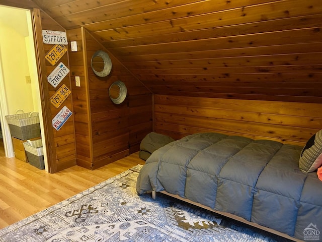 bedroom with lofted ceiling, wood-type flooring, wooden ceiling, and wood walls