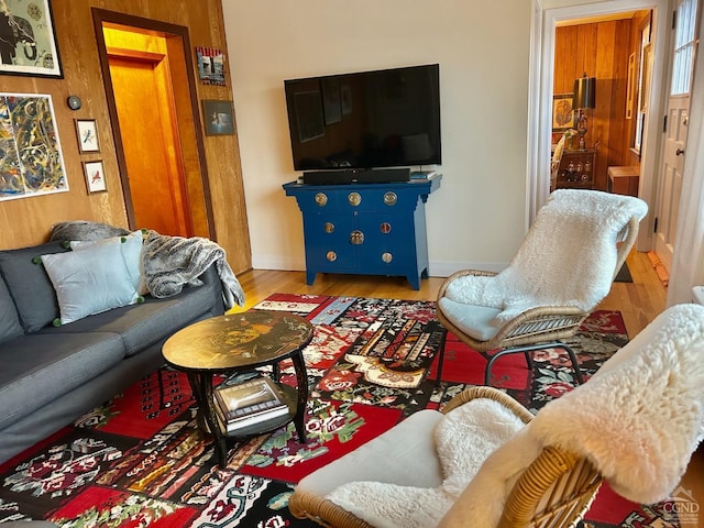 living room featuring hardwood / wood-style flooring and wooden walls