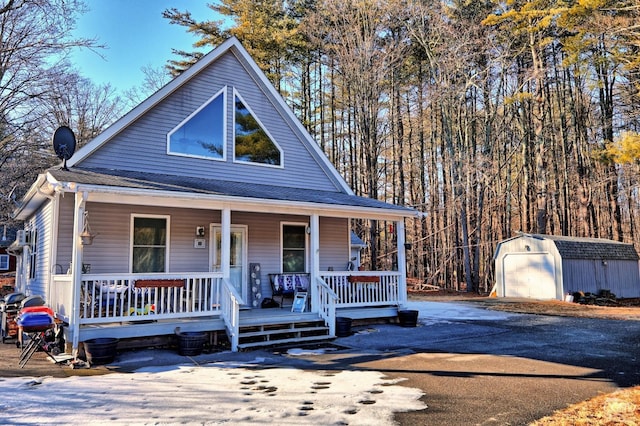 view of front of property with a porch, a garage, and a storage shed