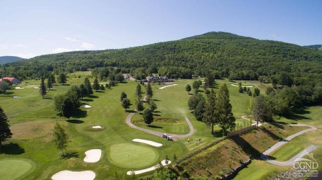 aerial view featuring a mountain view, golf course view, and a forest view