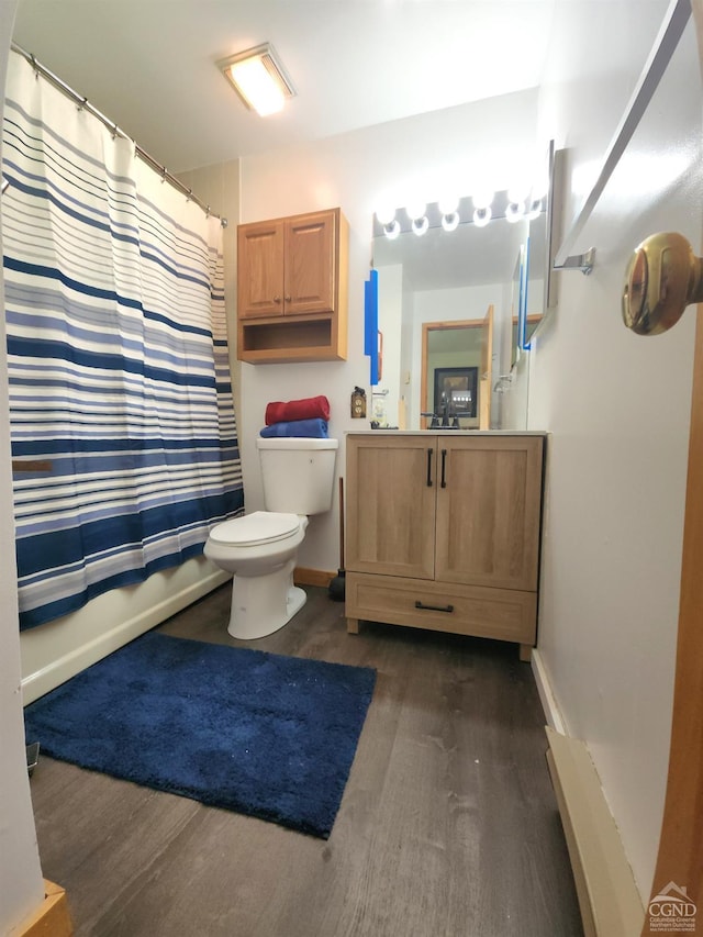 full bathroom with baseboards, toilet, wood finished floors, and vanity