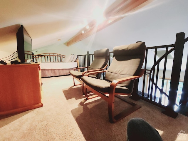 sitting room with lofted ceiling with beams and carpet flooring