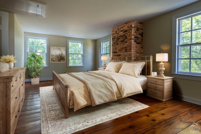 bedroom with dark hardwood / wood-style floors and multiple windows