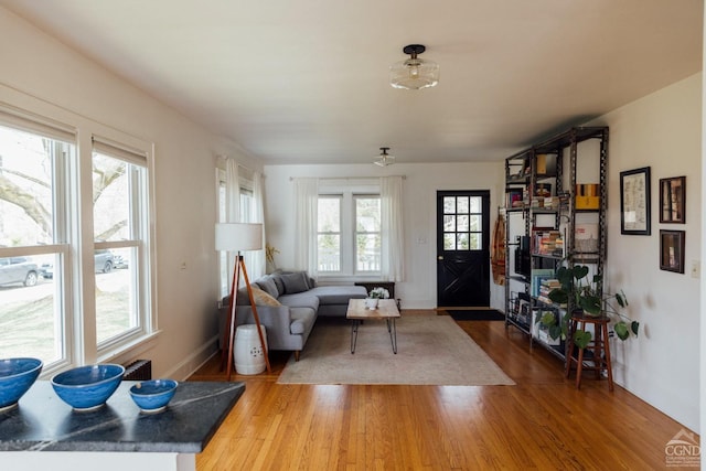 living area with baseboards and light wood finished floors
