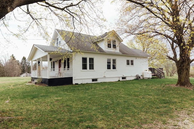 view of home's exterior featuring covered porch, a yard, and roof with shingles