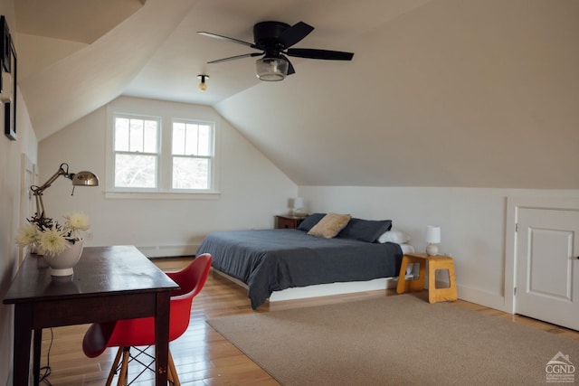 bedroom featuring baseboard heating, vaulted ceiling, and wood finished floors