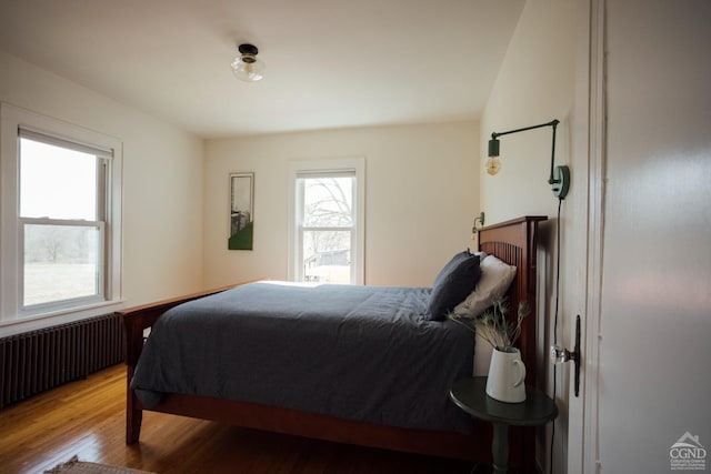 bedroom featuring radiator heating unit and wood finished floors