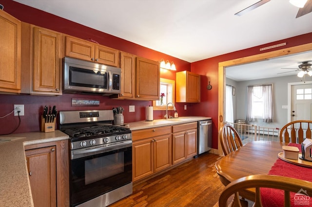 kitchen featuring a sink, appliances with stainless steel finishes, a ceiling fan, and light countertops