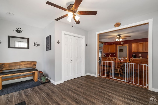 interior space featuring ceiling fan, baseboards, and dark wood finished floors