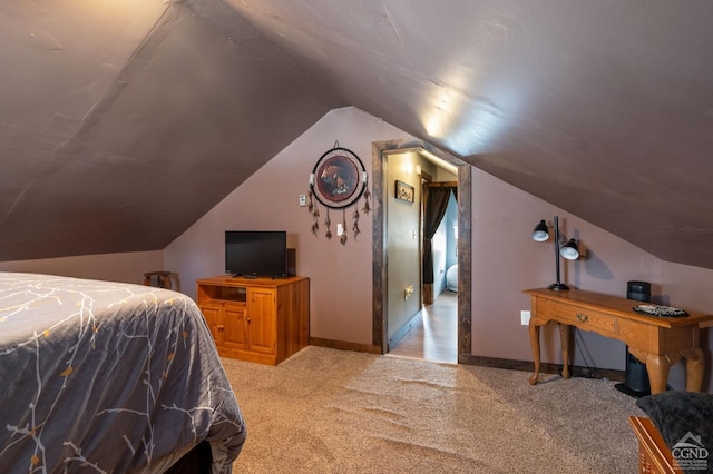 carpeted bedroom with lofted ceiling and baseboards