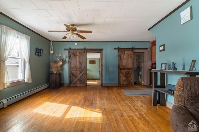 unfurnished living room with crown molding, a barn door, and a baseboard radiator