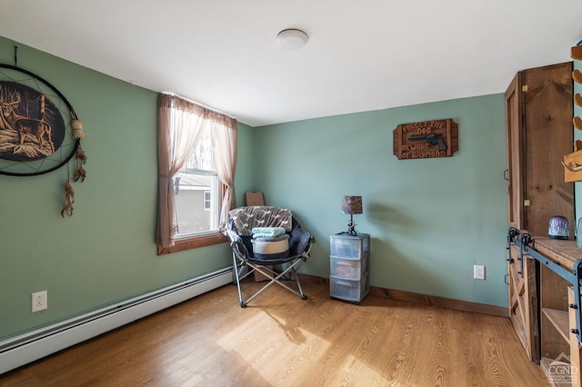 interior space with wood finished floors, baseboards, and a baseboard radiator