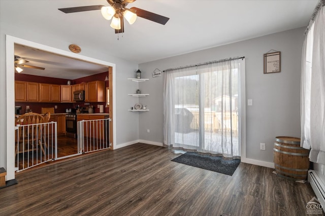 doorway featuring a ceiling fan, dark wood-style floors, baseboards, and a baseboard radiator