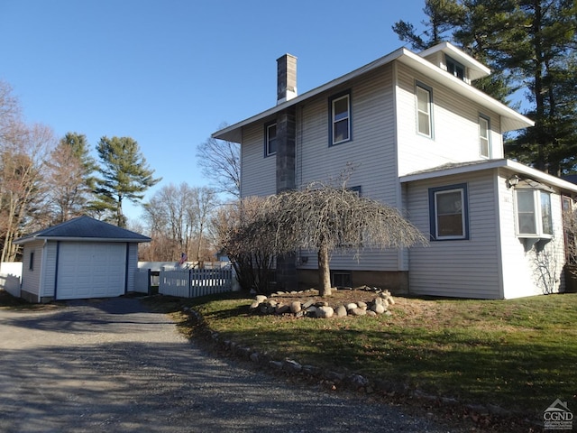 view of side of property with a garage, an outdoor structure, and a lawn