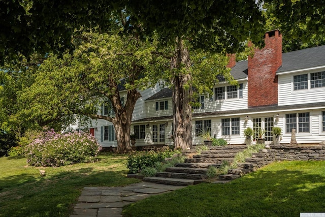 rear view of property featuring a lawn