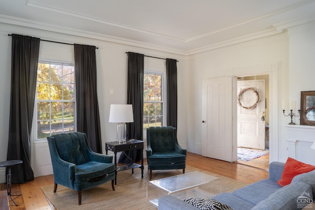 living area with light hardwood / wood-style flooring and ornamental molding