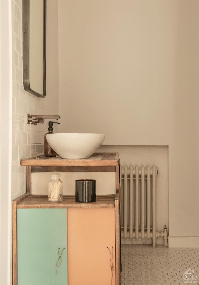 details featuring vanity, decorative backsplash, and radiator