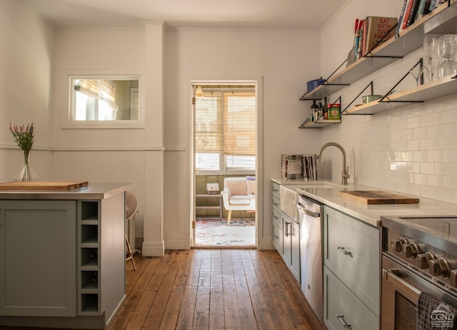 kitchen featuring stainless steel appliances, crown molding, dark wood-type flooring, sink, and gray cabinets