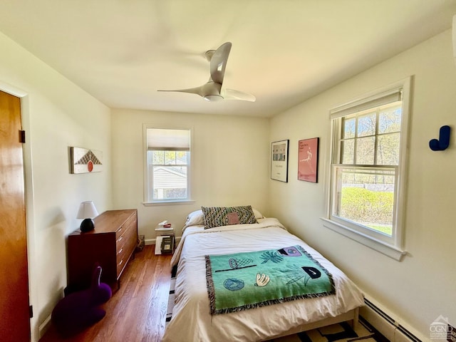 bedroom with a ceiling fan, dark wood-type flooring, baseboards, and baseboard heating