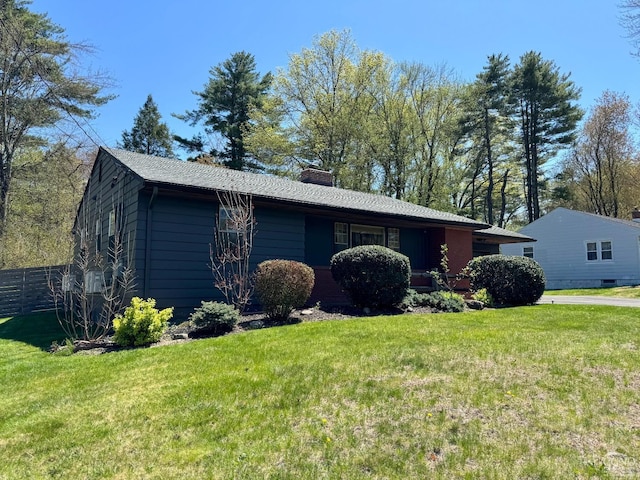 view of side of property with a chimney, fence, and a lawn