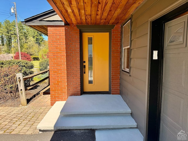 view of exterior entry featuring brick siding