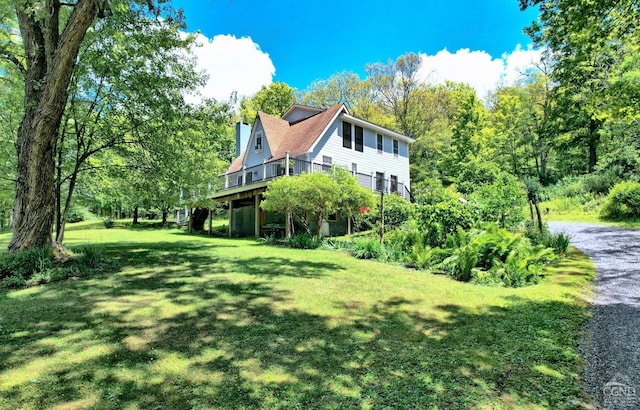 view of side of property featuring a wooden deck and a yard