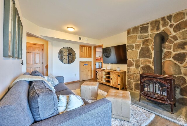 living room featuring a wood stove and light hardwood / wood-style flooring