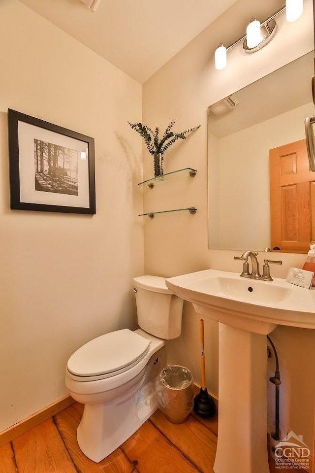 bathroom featuring hardwood / wood-style flooring and toilet