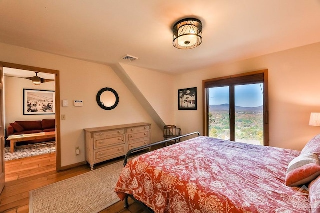 bedroom with a mountain view and light wood-type flooring