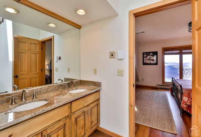 bathroom with hardwood / wood-style floors, vanity, and a baseboard heating unit