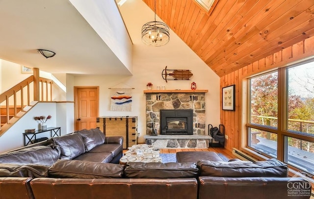 living room featuring a skylight, an inviting chandelier, a stone fireplace, hardwood / wood-style floors, and wooden walls