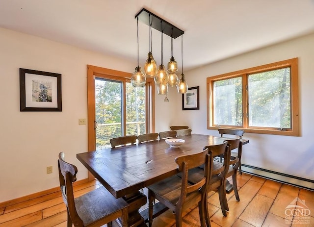 dining room with light hardwood / wood-style floors, baseboard heating, a wealth of natural light, and a chandelier