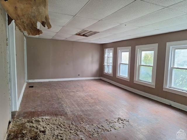 unfurnished room with wood-type flooring and a paneled ceiling