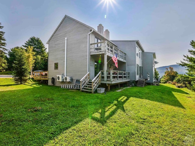 rear view of house with a yard and a wooden deck