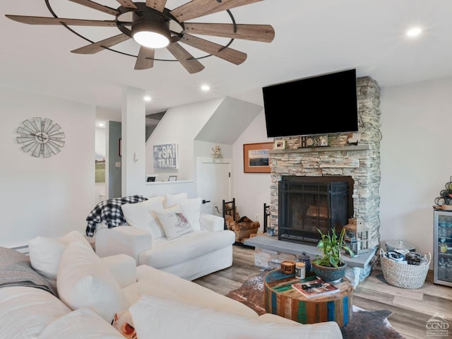 living room featuring a fireplace, light hardwood / wood-style floors, and ceiling fan