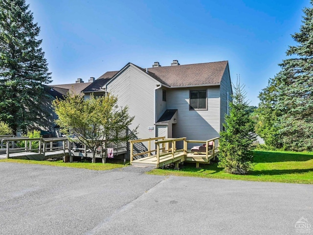 view of front facade featuring a deck and a front lawn