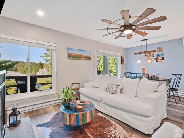 living room featuring a fireplace, light hardwood / wood-style flooring, ceiling fan, and sink