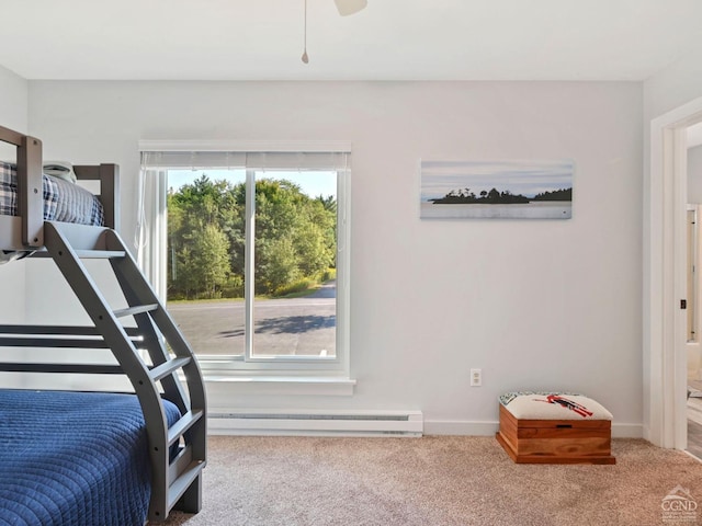 bedroom with carpet flooring, ceiling fan, and a baseboard heating unit