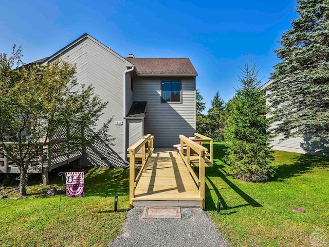 back of property featuring a wooden deck and a yard