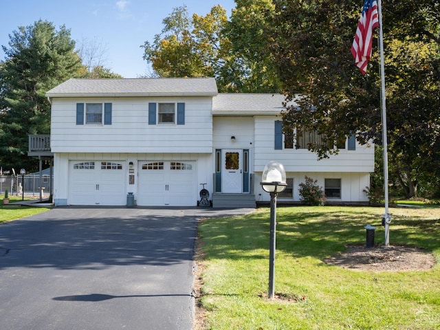 raised ranch featuring a front lawn and a garage