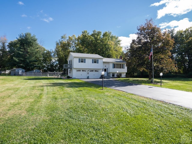 raised ranch featuring a front yard and a garage