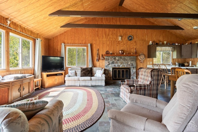 living room featuring vaulted ceiling with beams, a stone fireplace, plenty of natural light, and wooden ceiling