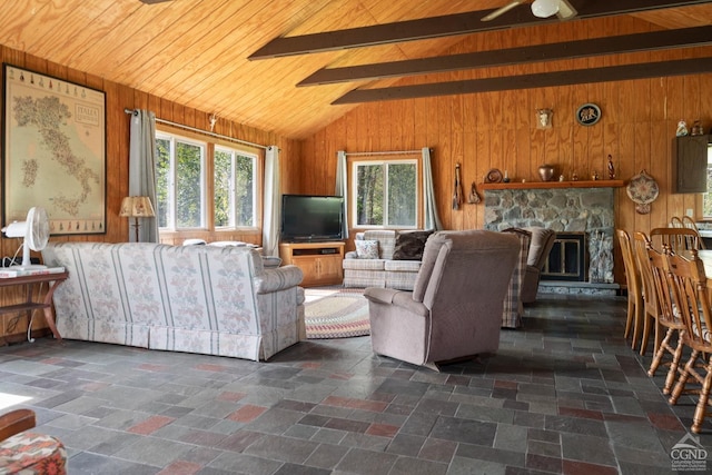 living room featuring wood walls, vaulted ceiling with beams, ceiling fan, a fireplace, and wood ceiling