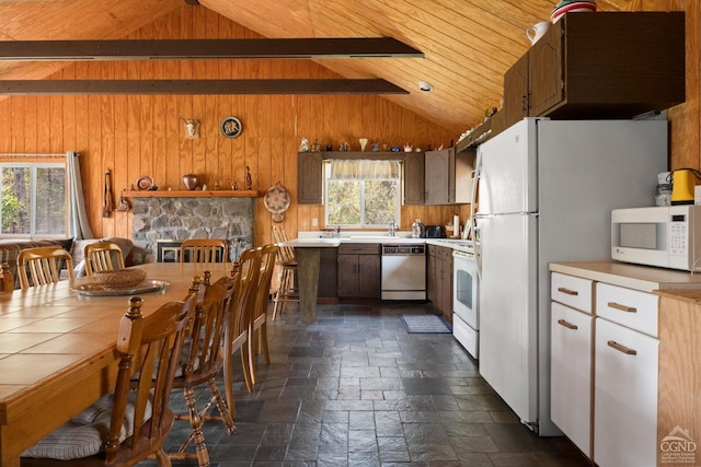 kitchen featuring white appliances, lofted ceiling with beams, wooden ceiling, and wood walls