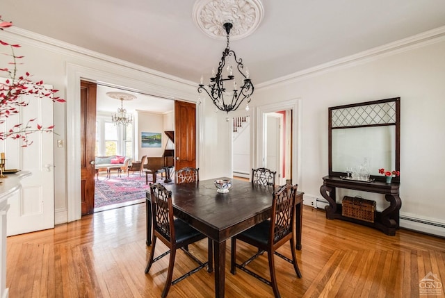 dining room featuring hardwood / wood-style floors, ornamental molding, and a chandelier